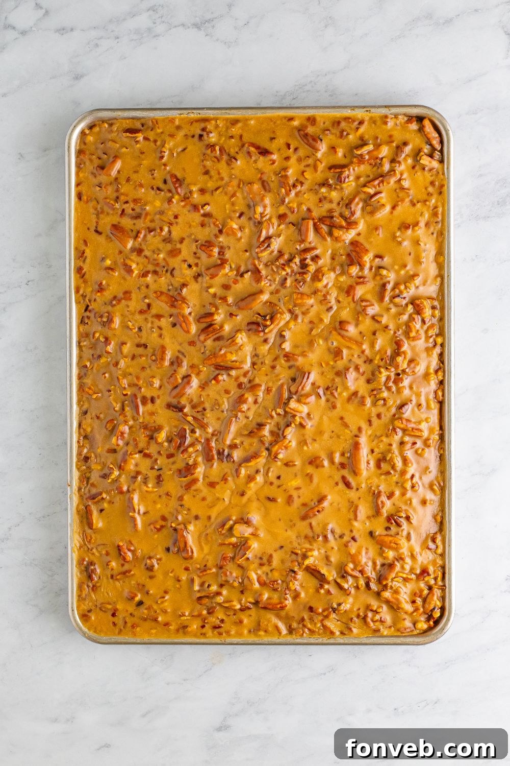 An inviting overhead shot of the completed Pumpkin Snack Cake, generously covered with golden praline icing, still in its baking pan.