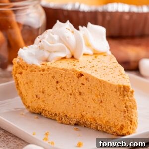 Slice of Marshmallow Pumpkin Pie on plate with a few crumbs from crust sprinkled on around the table