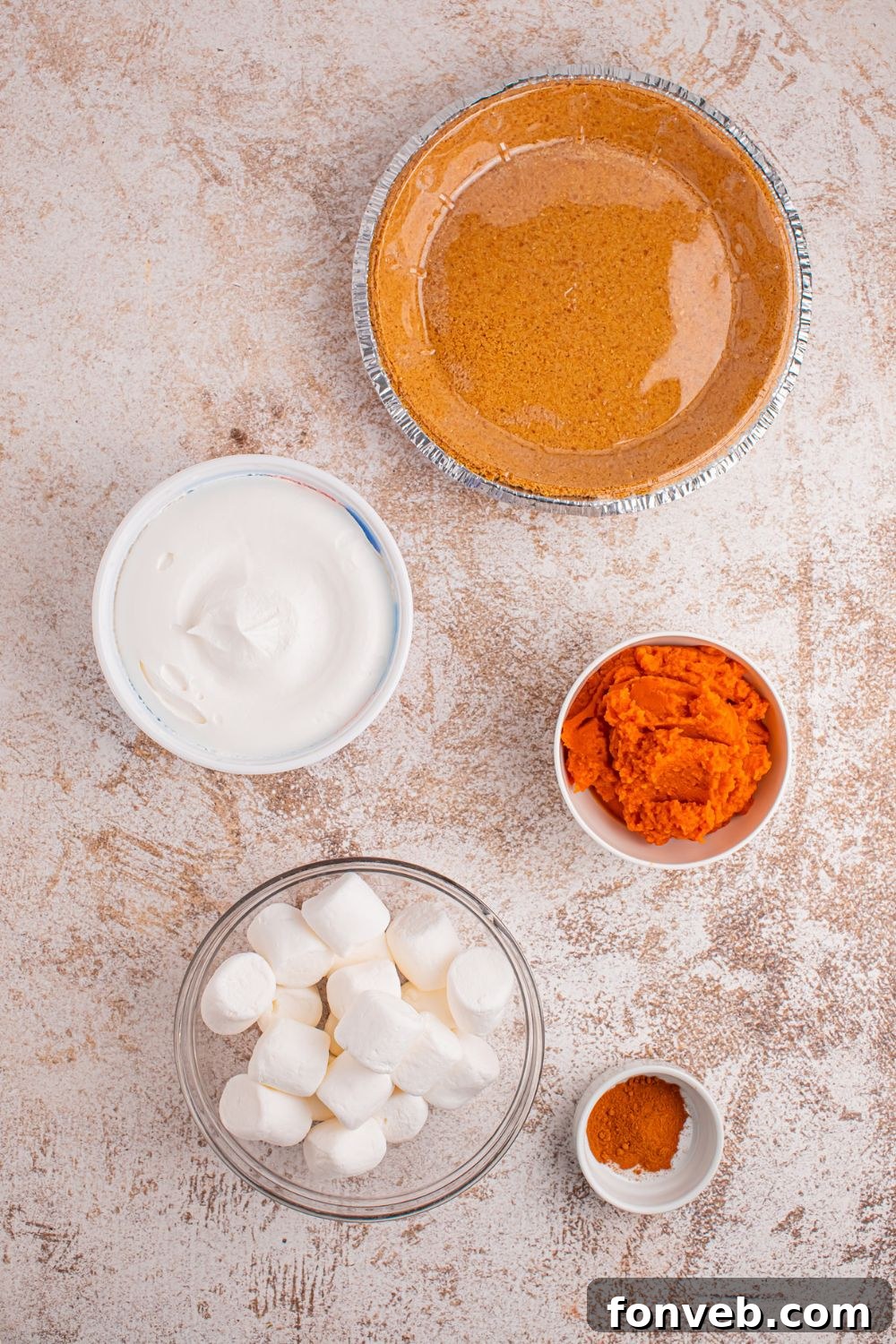 ingredients for a pumpkin marshmallow pie in single serve bowls sitting on a table