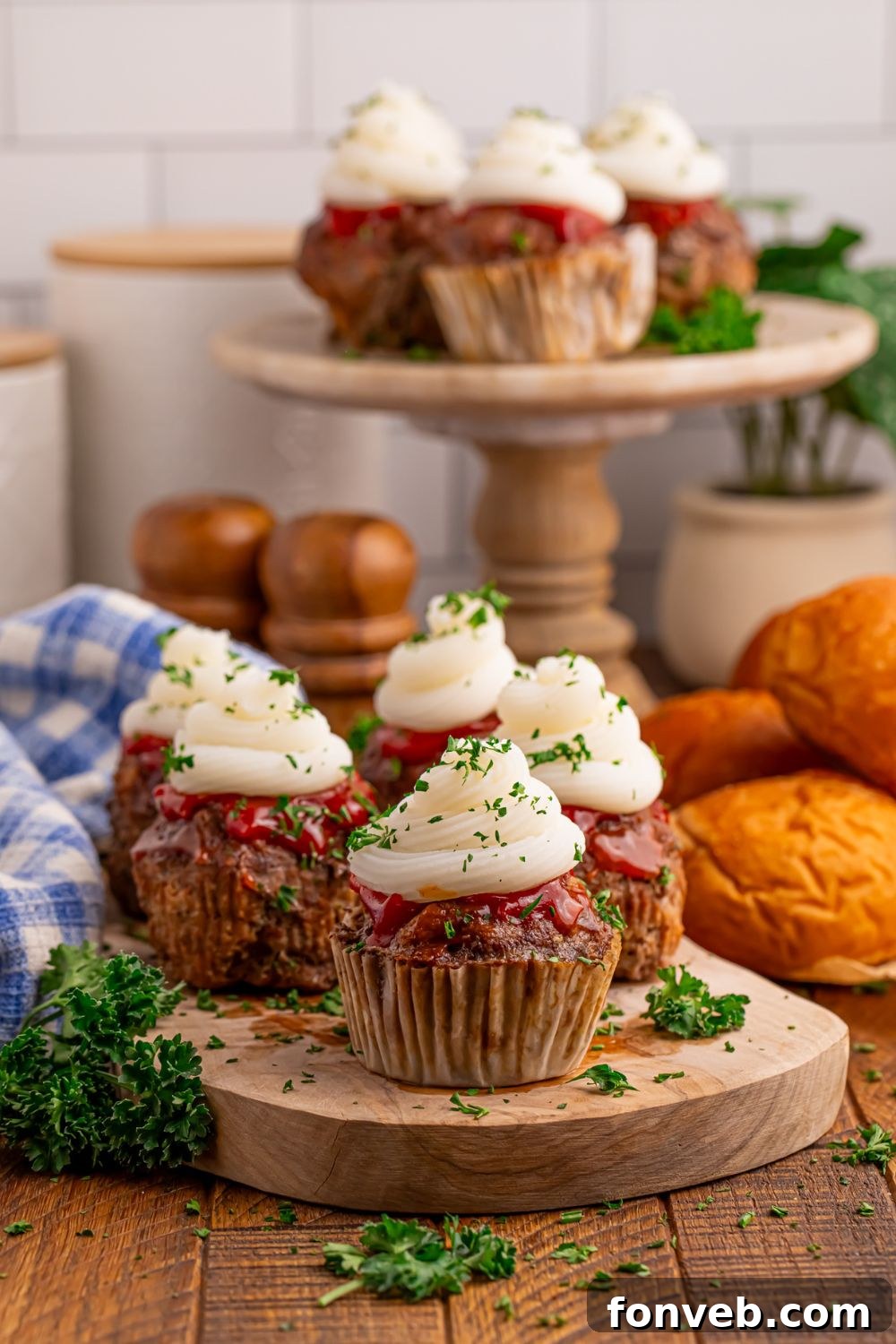 Meatloaf Cupcakes on table and on platters with parsley and dinner rolls around it on table