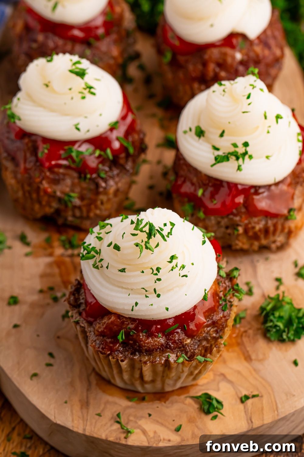 overhead look of these mashed potato topped meatloaf cupcakes sitting on a wooden table