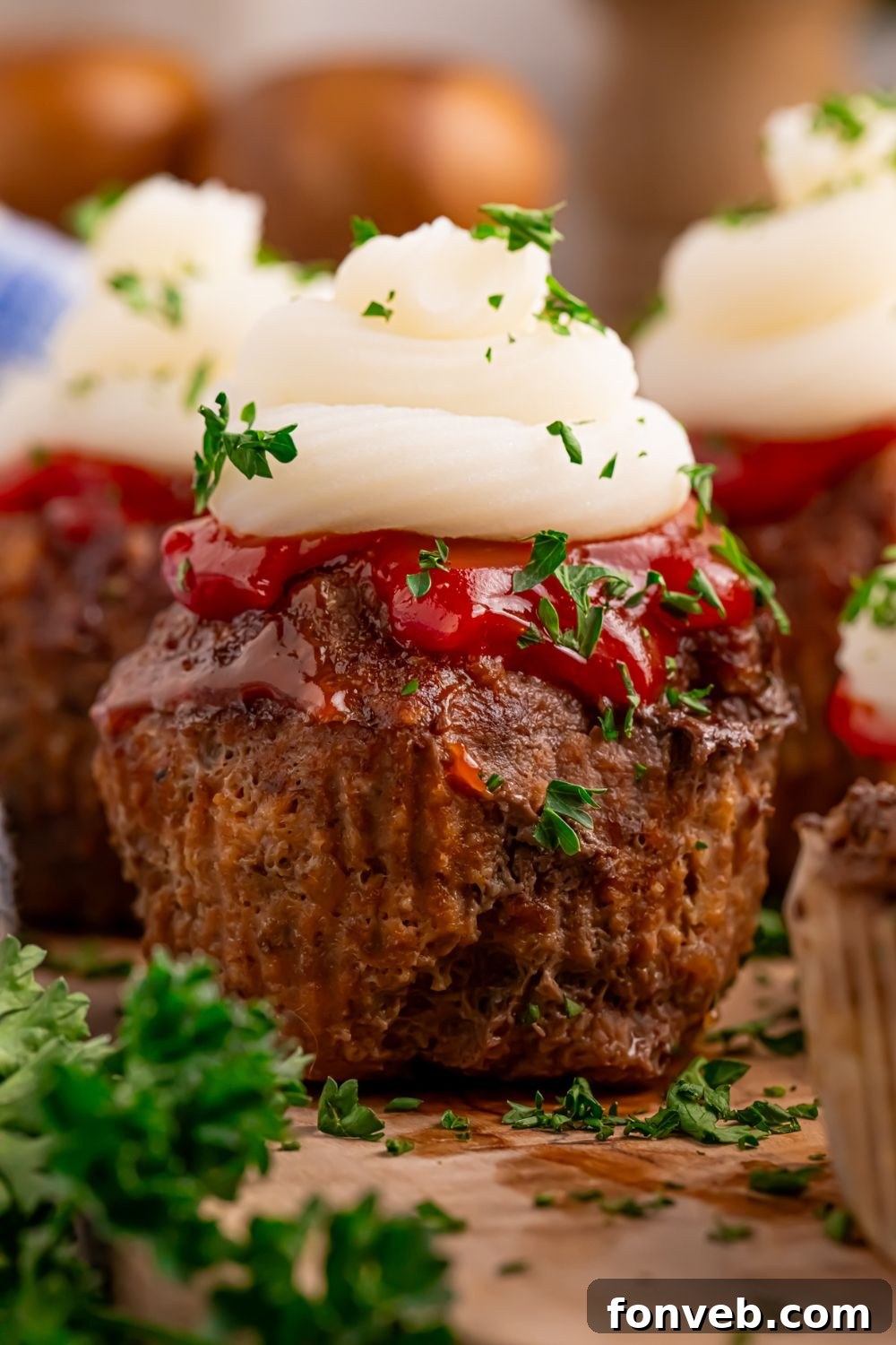 Meatloaf Cupcakes on table with parsley on the side for a pop of green in picture 