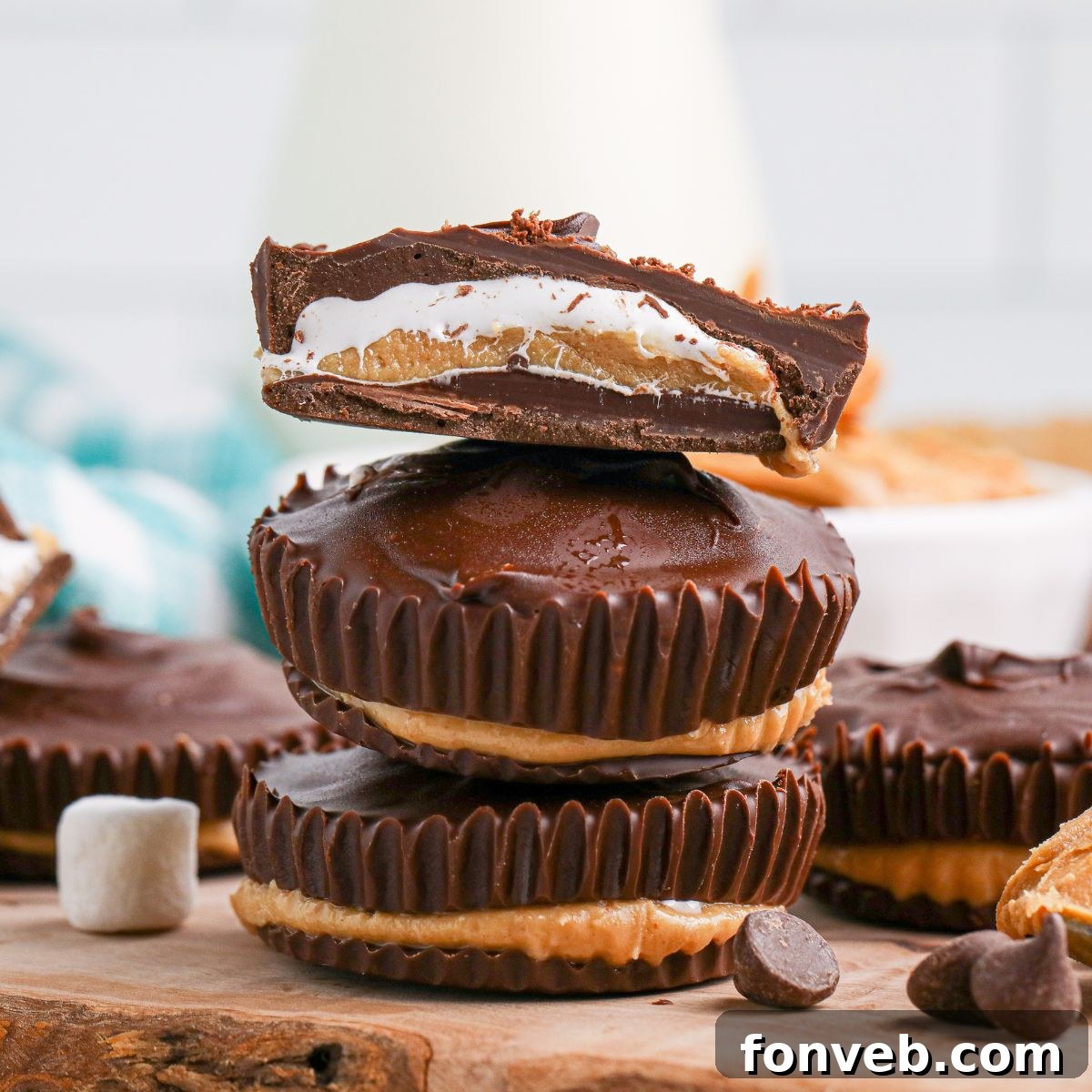 Peanut Butter Fluff Cups 2 Peanut Butter Marshmallow Cups stacked on wooden cutting board with top one cut in half so you can see the layers
