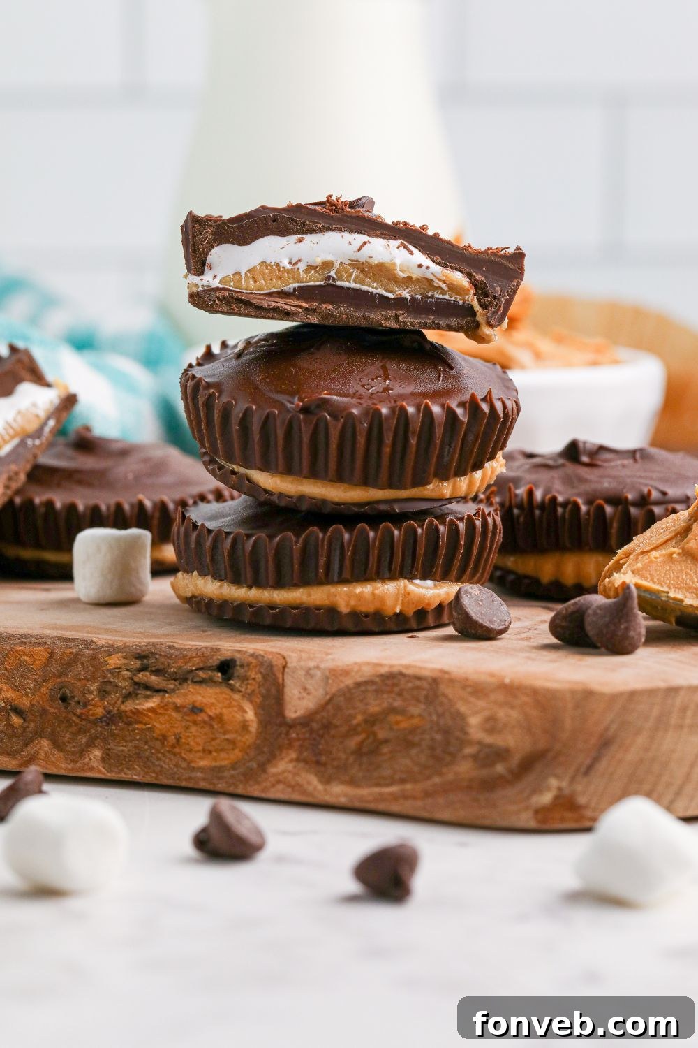 Peanut Butter Fluff Cups 11 Peanut Butter Marshmallow Cups stacked on wooden tray with one cut in half to see layers