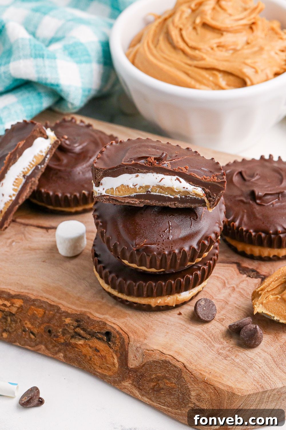 Peanut Butter Fluff Cups 3 Peanut Butter Marshmallow Cups on wooden table with marshmallows and chocolate chips around cups on table