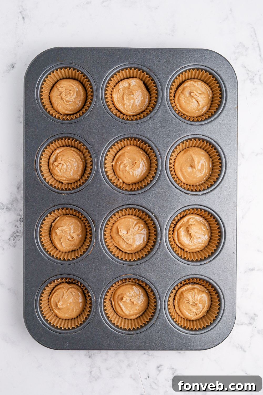 Peanut Butter Fluff Cups 7 peanut butter poured over chocolate in muffin tin for making Peanut Butter Marshmallow Cups