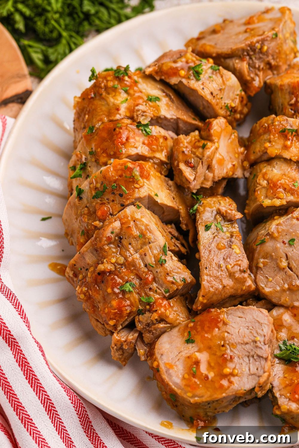 Crock Pot Apricot Pork Tenderloin sliced into medallions on a plate 
