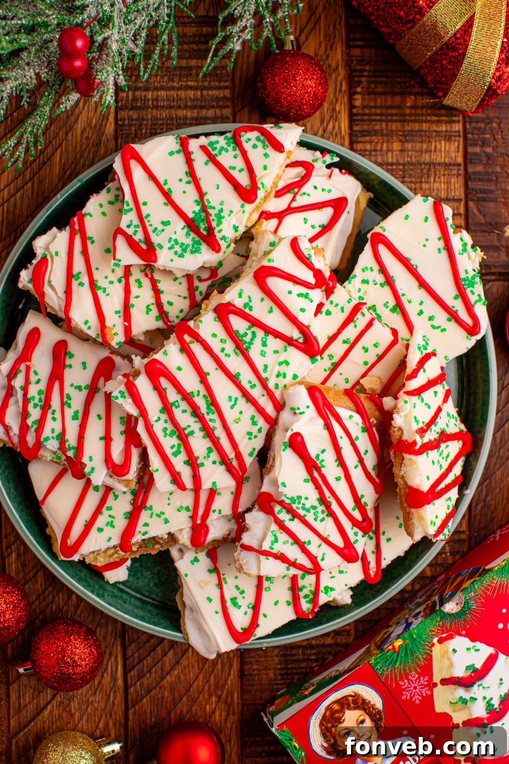 Addictive Little Debbie Christmas Tree Cake Toffee Bark 11 Christmas Tree Crack on a plate with holiday decor around the plate