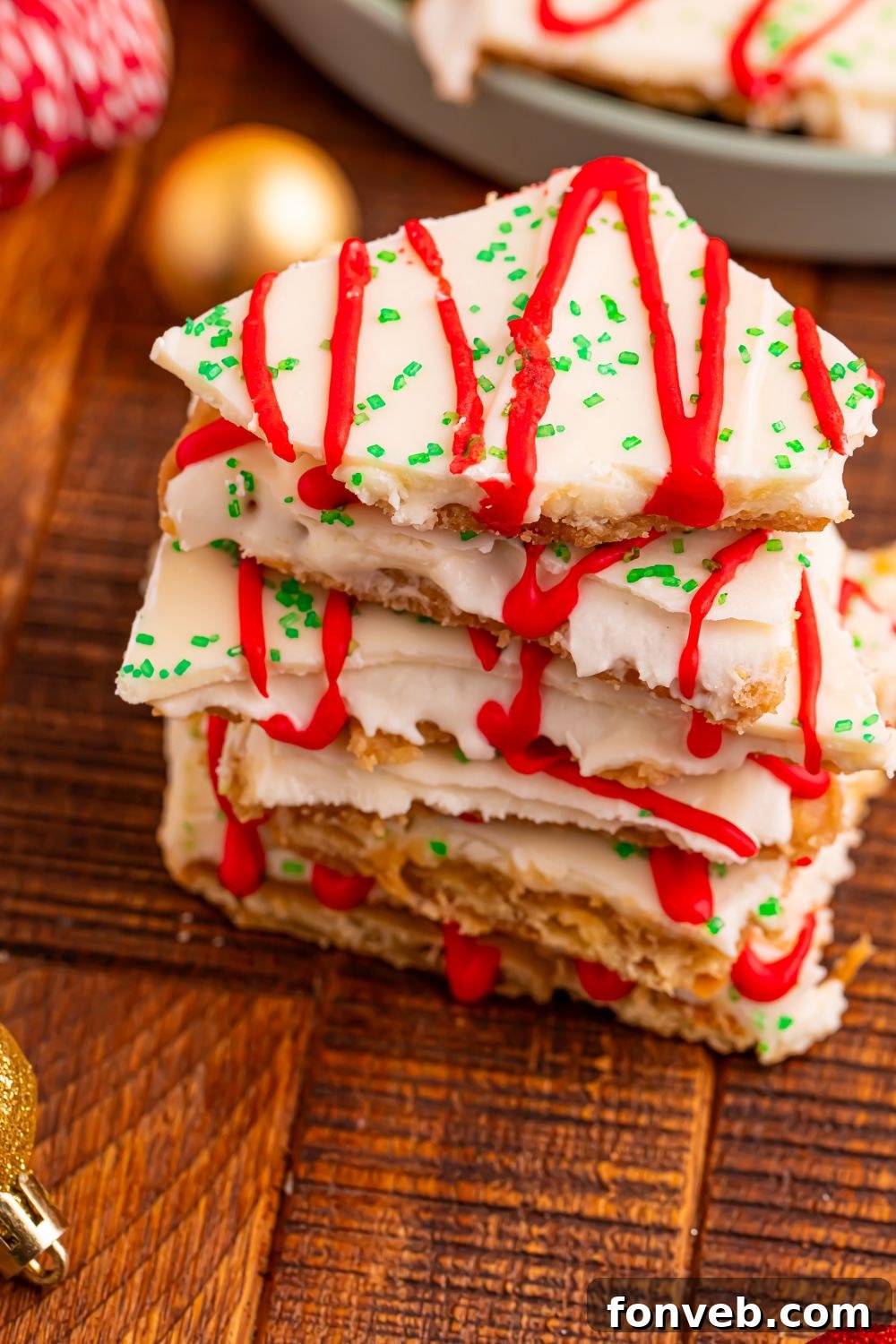 Addictive Little Debbie Christmas Tree Cake Toffee Bark 15 Christmas Tree Crack stacked on wooden table with Christmas decor behind it on table