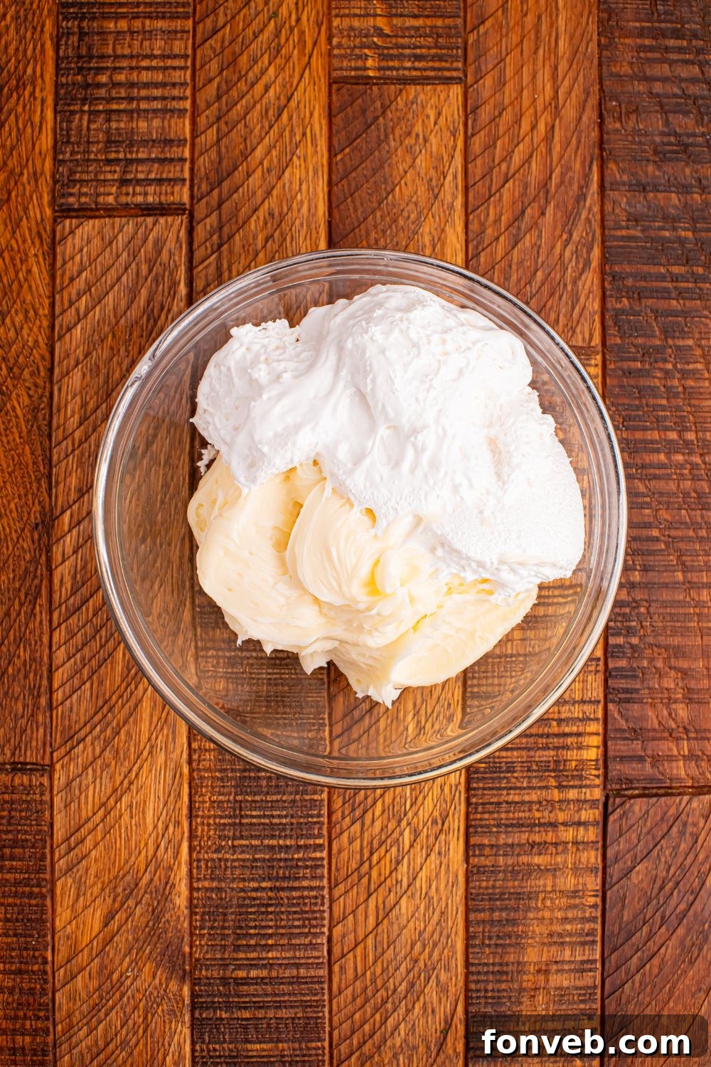 Addictive Little Debbie Christmas Tree Cake Toffee Bark 6 cream cheese frosting and marshmallow fluff in a bowl on wooden table for Christmas Tree Crack