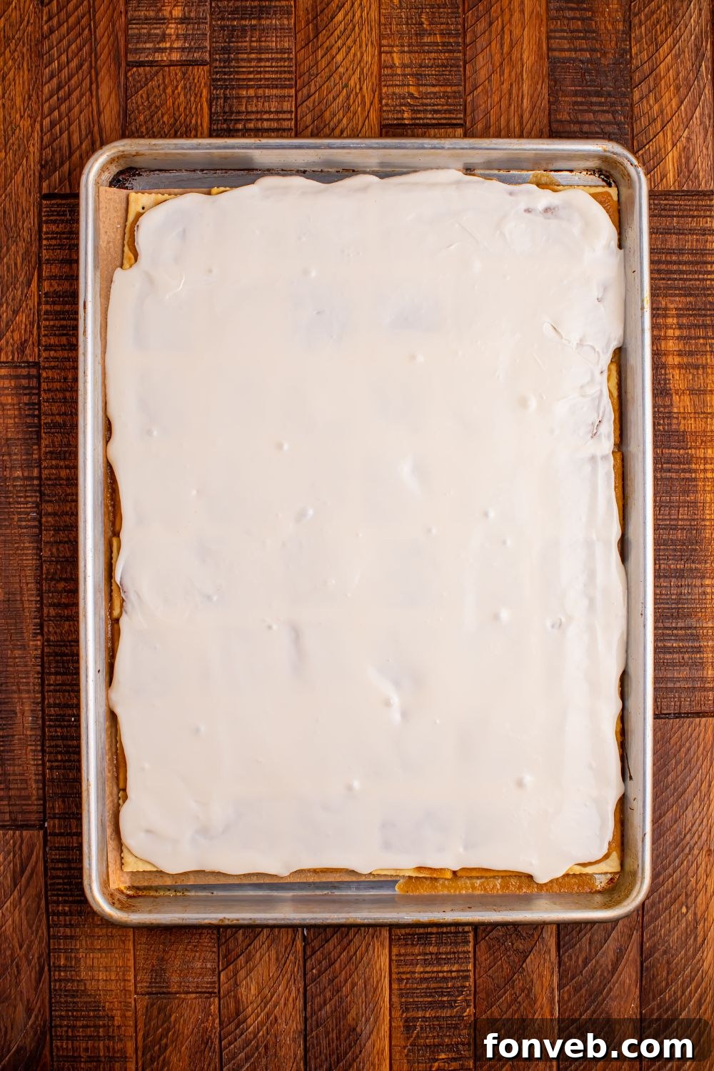 Addictive Little Debbie Christmas Tree Cake Toffee Bark 7 Christmas Tree Crack in a pan with the cream cheese frosting spread on top