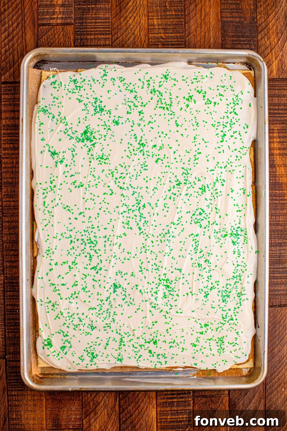 Addictive Little Debbie Christmas Tree Cake Toffee Bark 8 overhead view of Christmas Tree Crack in a sheet pan with green sprinkles on top
