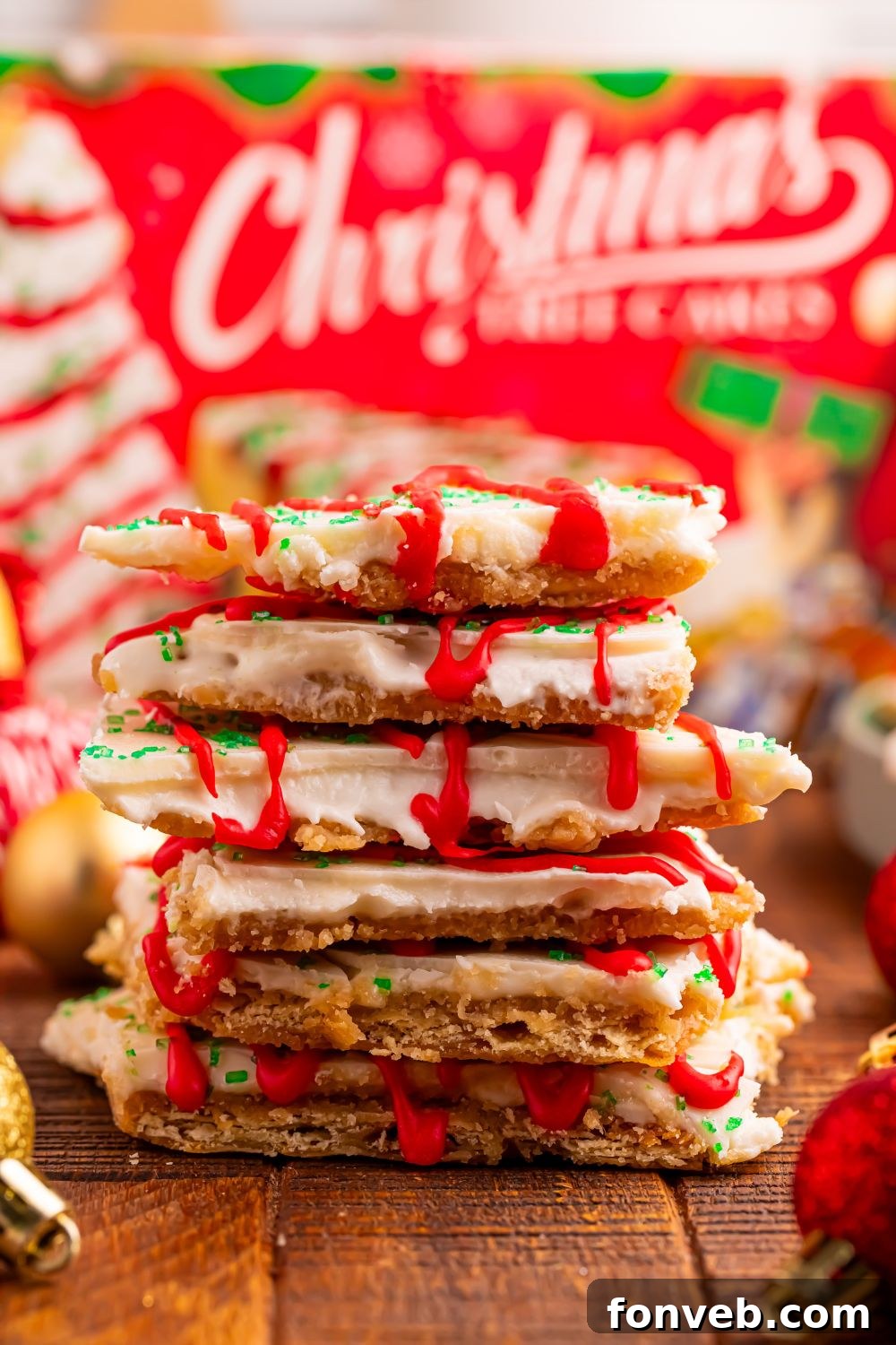 Addictive Little Debbie Christmas Tree Cake Toffee Bark 10 Christmas Tree Crack stacked on top of each other with Little Debbie cake box behind it on table