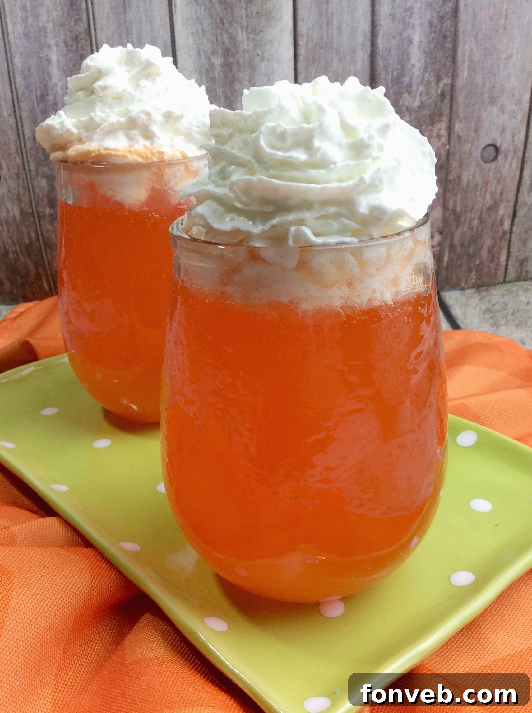 Cocktail ingredients, including orange soda and vodkas, being prepared in a shaker