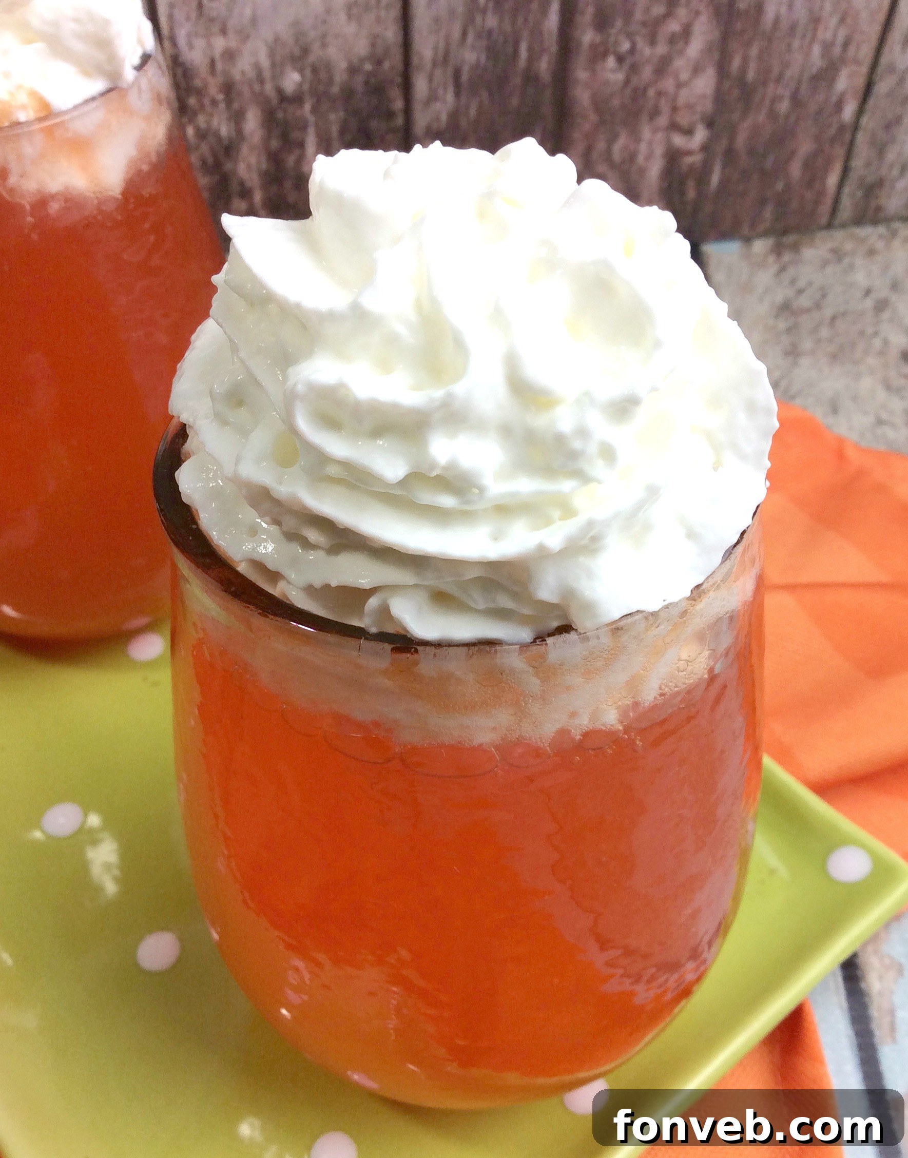 Finished Orange Creamsicle Cocktail with a generous topping of whipped cream and an orange slice