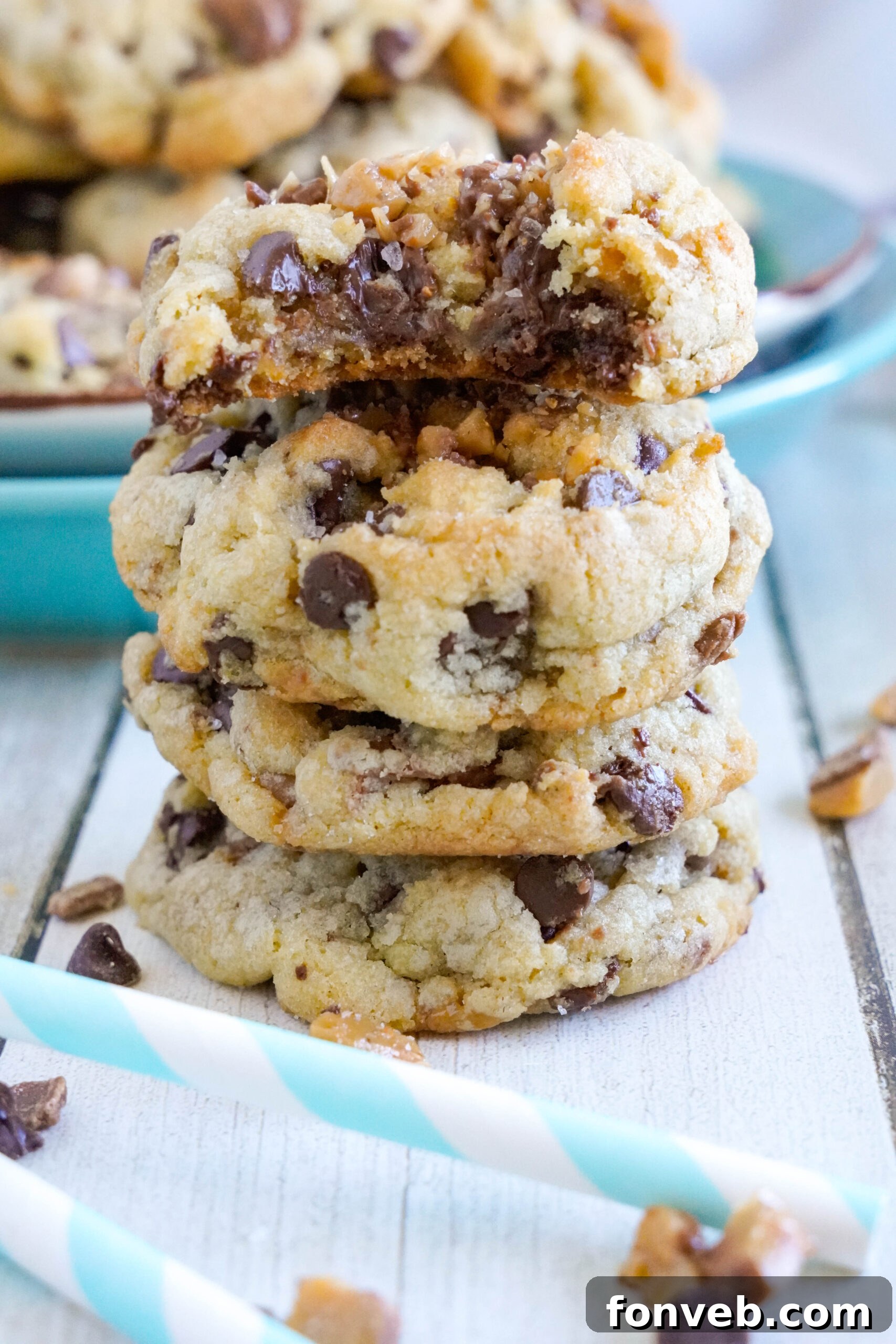 Chocolate Chip Toffee Cookies stacked on top of each other with crumble of cookies around it 