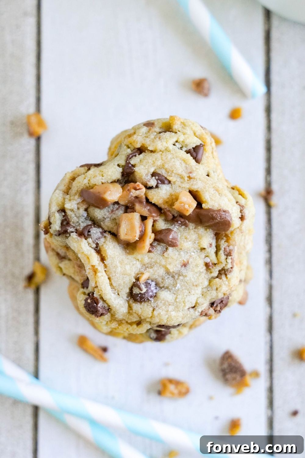 Chocolate Chip Toffee Cookies stacked on top of each other with one cookie with it bit in half 