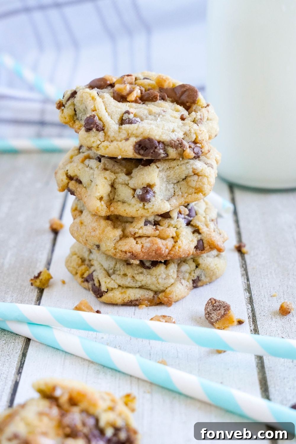 Chocolate Chip Toffee Cookies stacked on top of each other with crumble of cookies around it 
