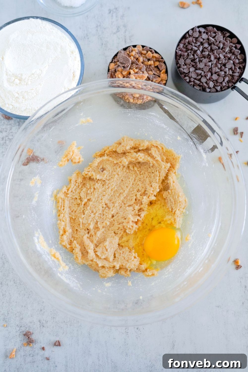 creamed butter and sugar mixed together with an egg on top in a glass bowl 