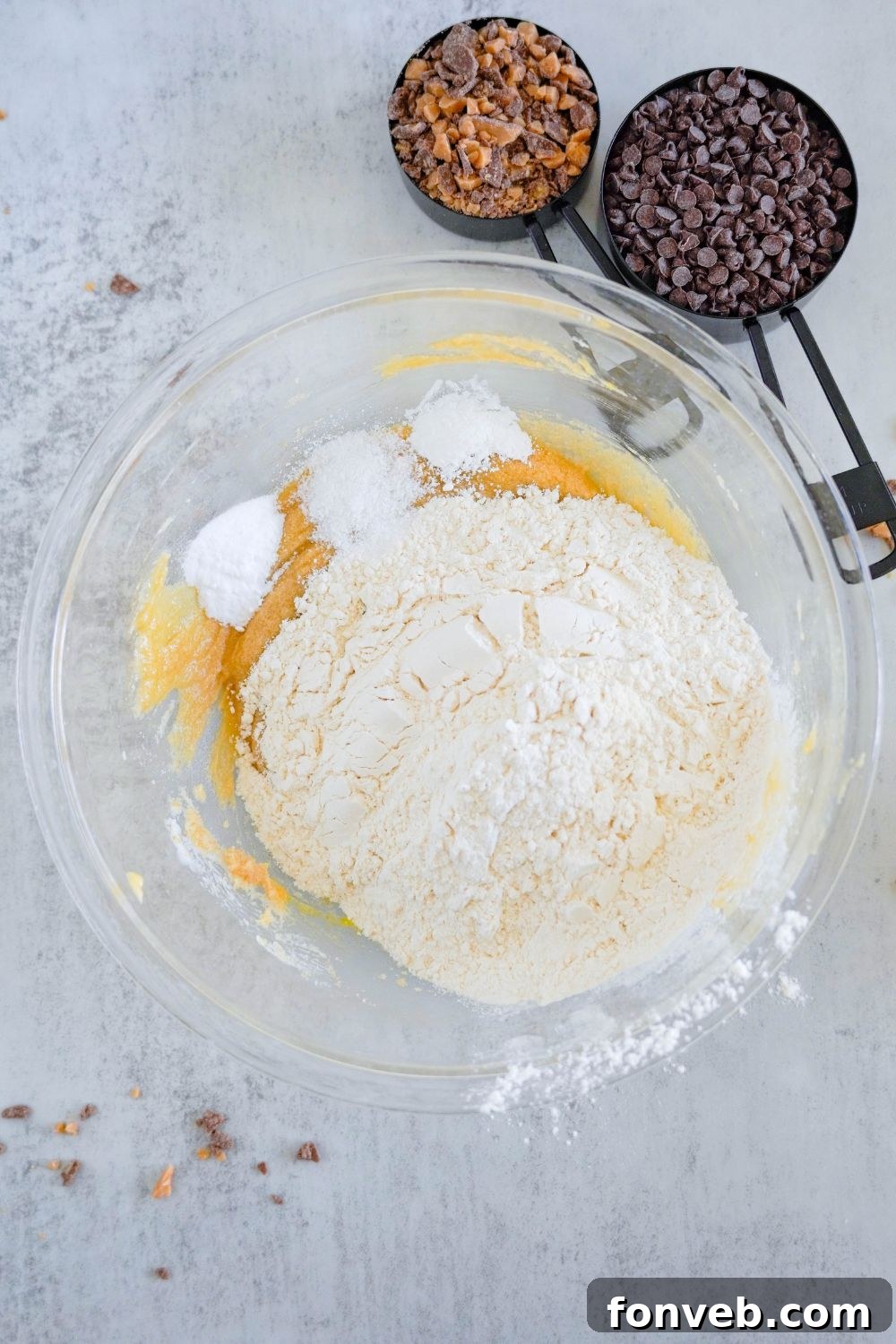 wet and dry ingredients added into a bowl to make Chocolate Chip Toffee Cookies