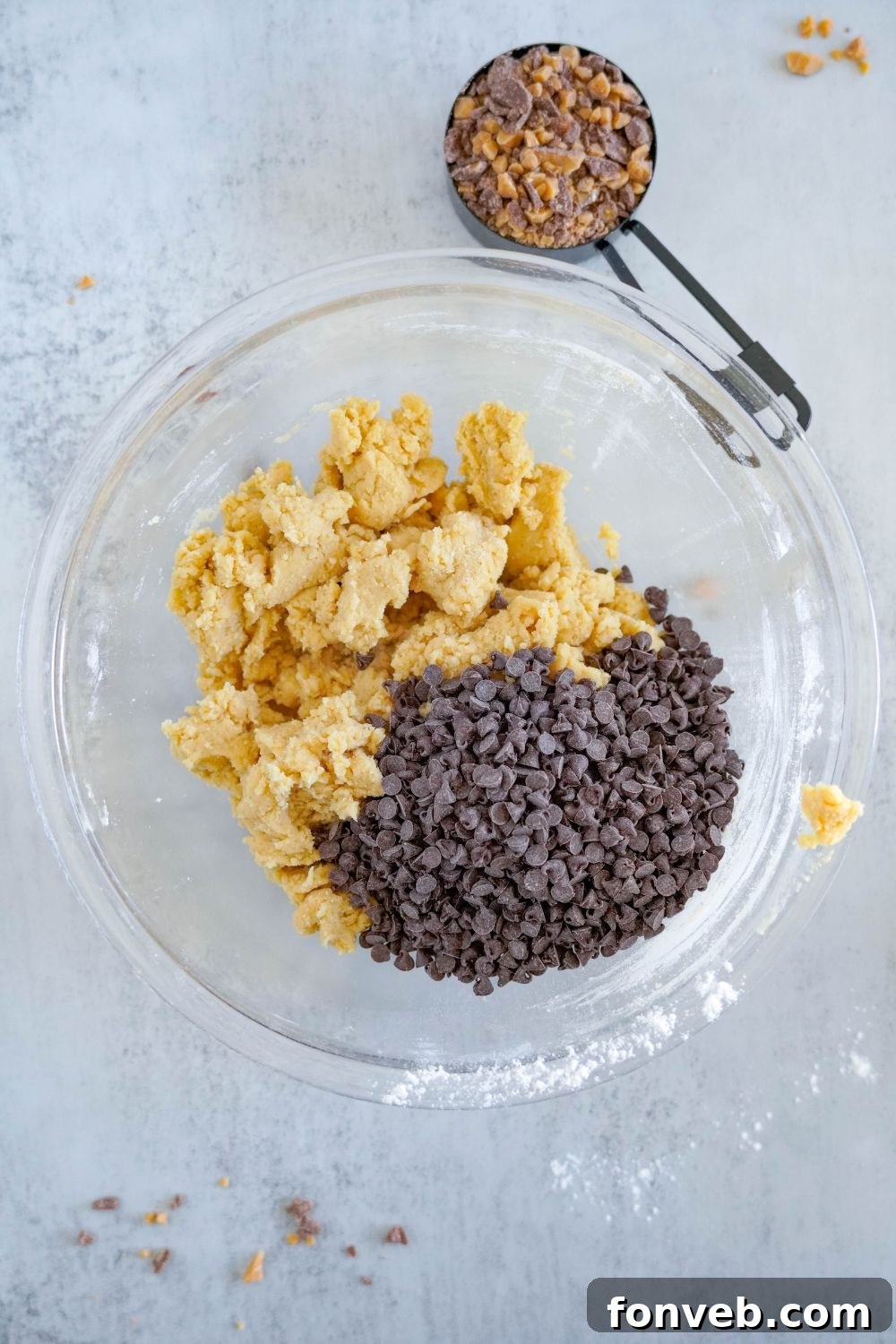 chocolate chip cookie dough with a bunch of chocolate chips on top of cookie dough 