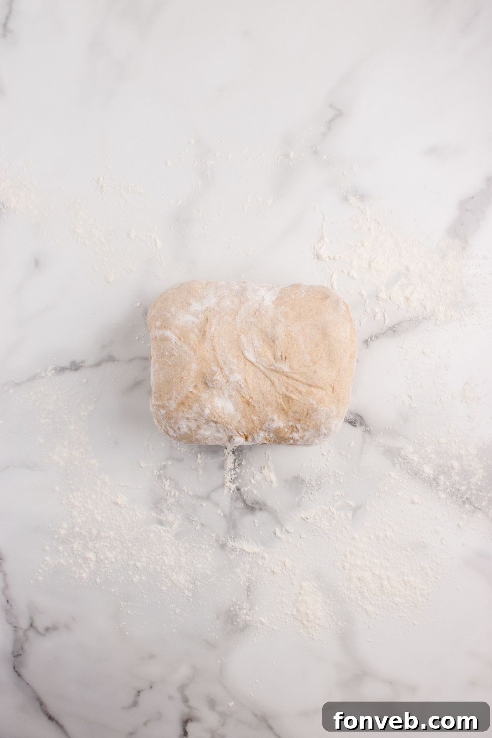 rolled bread dough on a marble countertop 