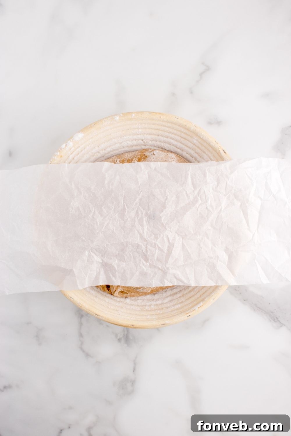 cinnamon raisin bread dough in a bowl covered with wax paper 