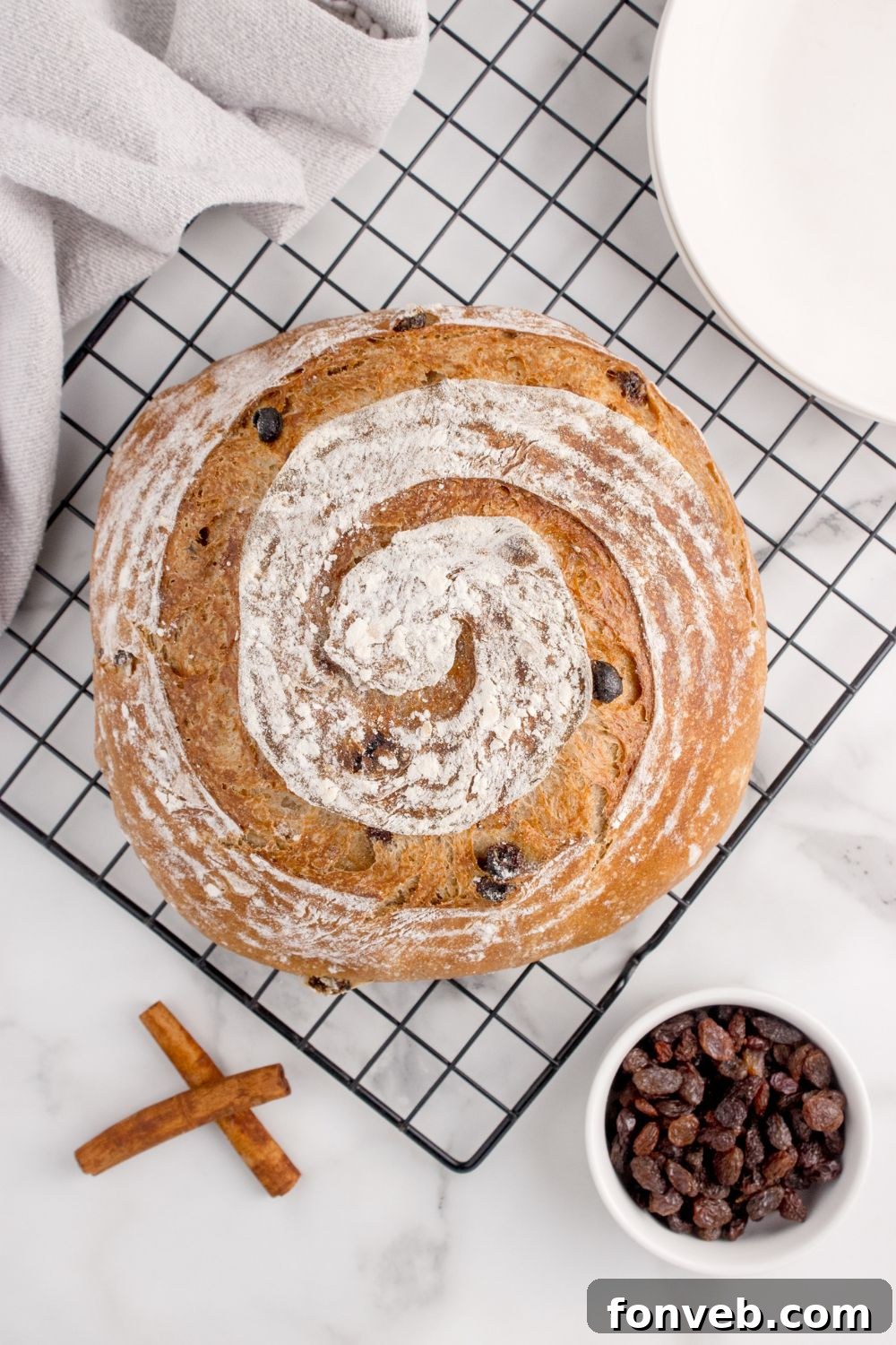 baked cinnamon raisin bread on cooling rack sitting on table 