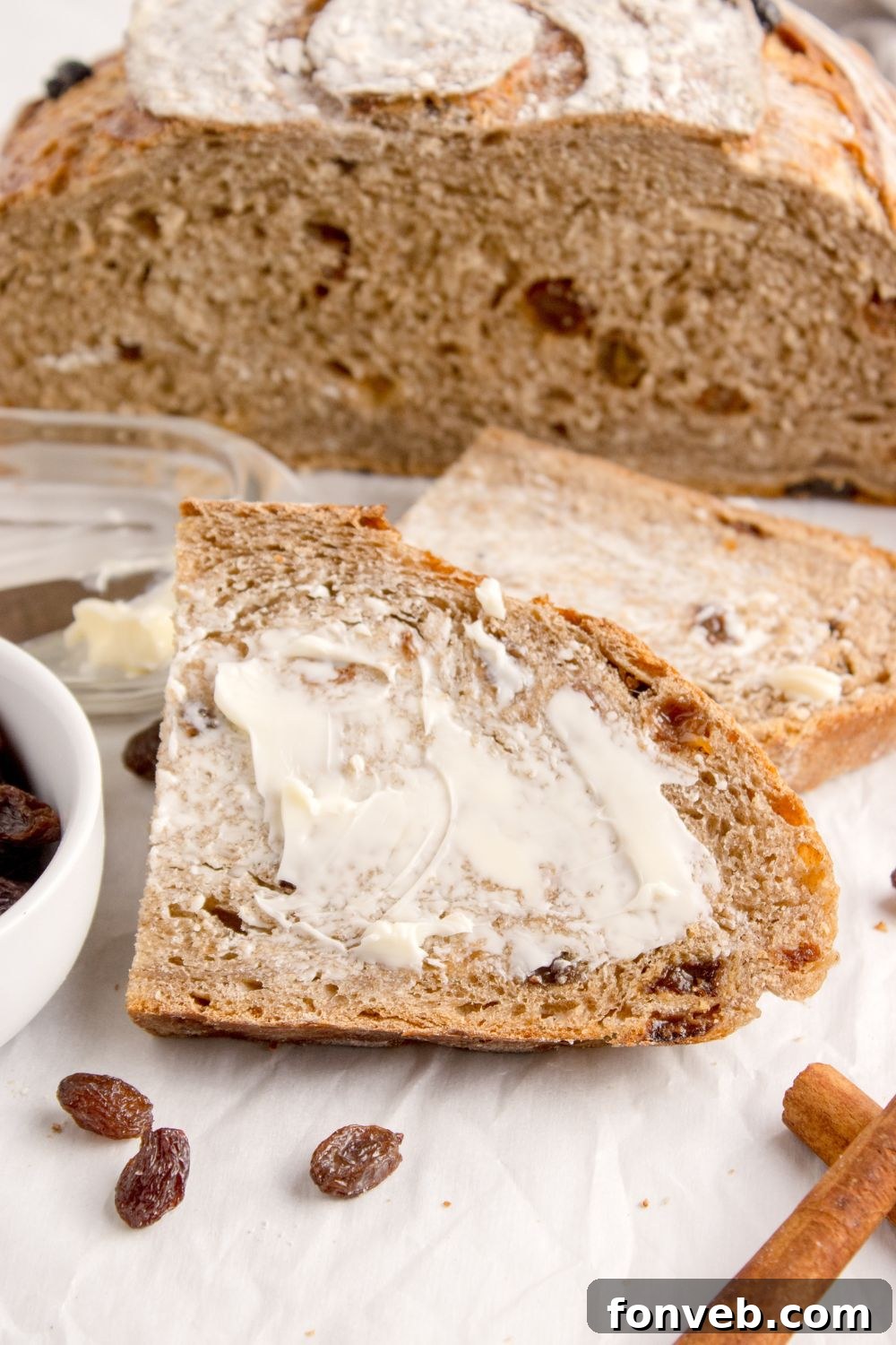 slice of cinnamon raisin bread with butter slathered on top of it 