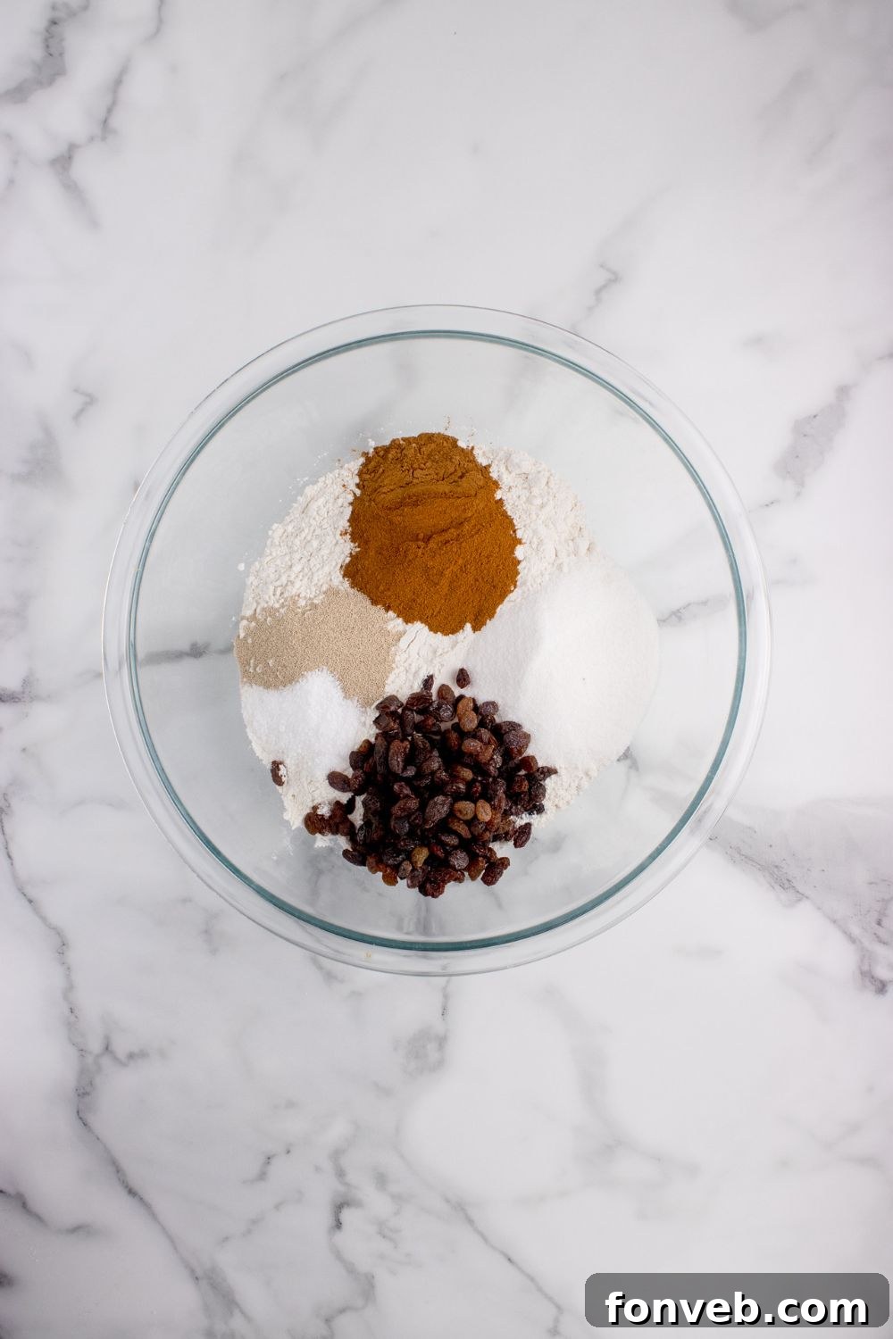 spices and raisins in a bowl for cinnamon raisin bread on counter 