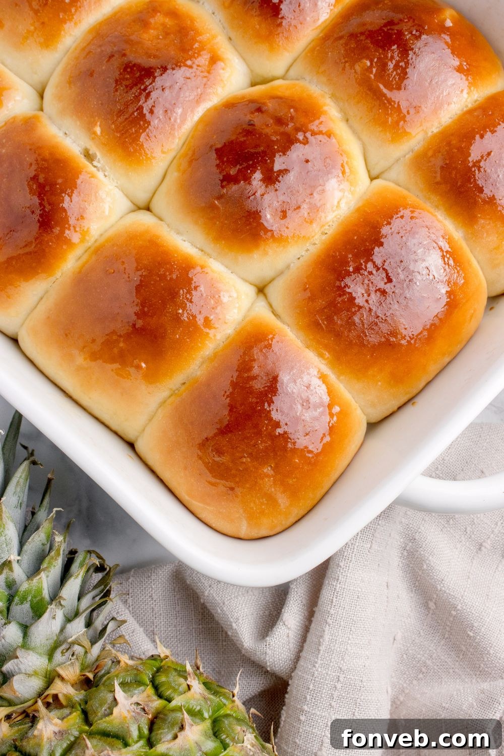 Tropical Dinner Buns 18 sweet hawaiian rolls in a pan on table with a pineapple on side of table