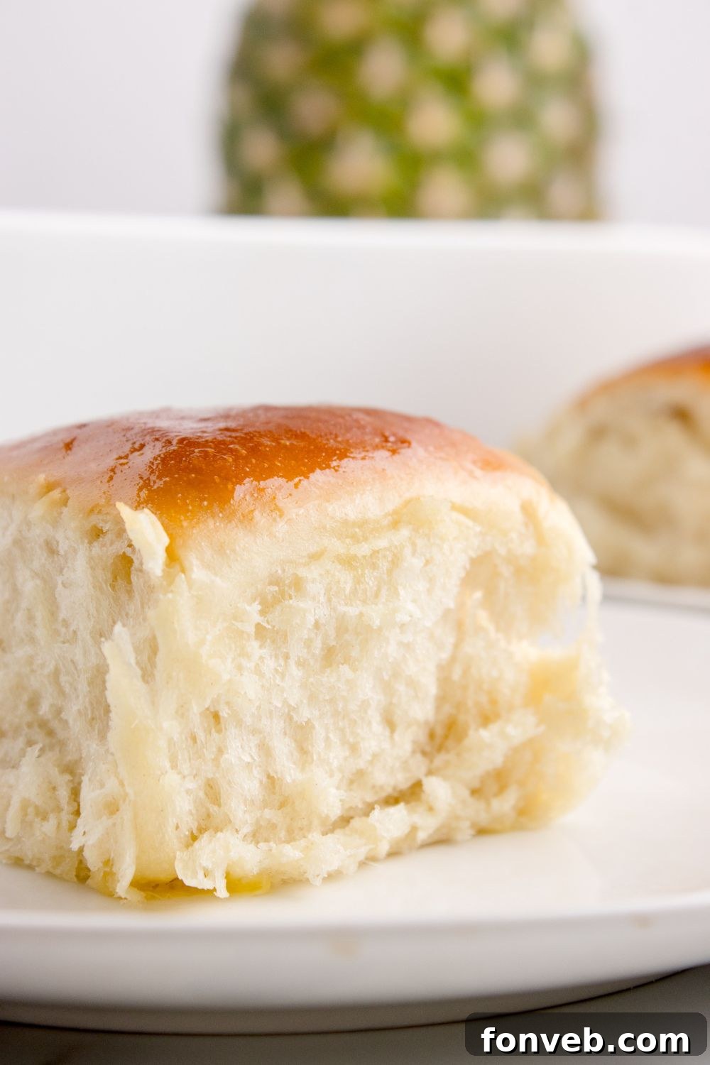 Tropical Dinner Buns 20 fluffy Hawaiian roll sitting on table with a pineapple sitting in the background