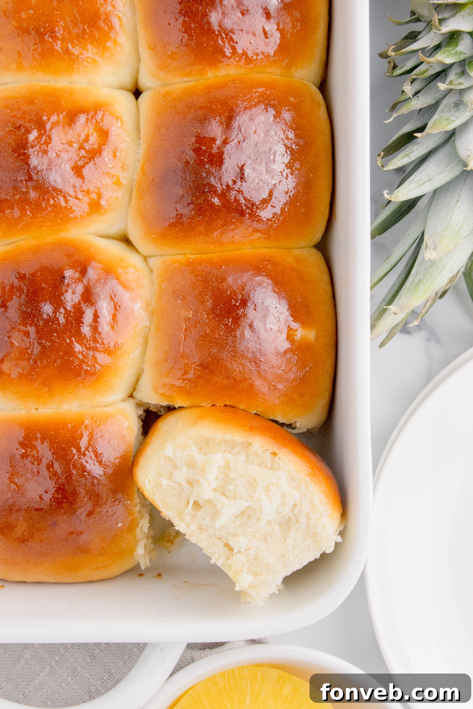 Tropical Dinner Buns 5 Hawaiian dinner rolls in a baking dish with one on its side showing texture