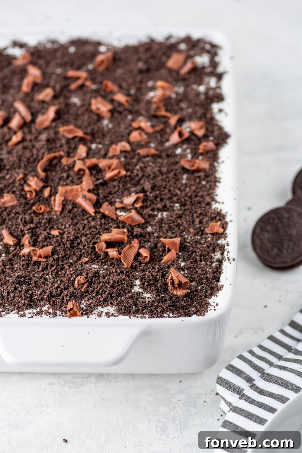 Ultimate Chocolate Oreo Delight 17 An overhead view of the Chocolate Oreo Lush dessert in a pan, resting on a wooden table, emphasizing its beautifully arranged layers.