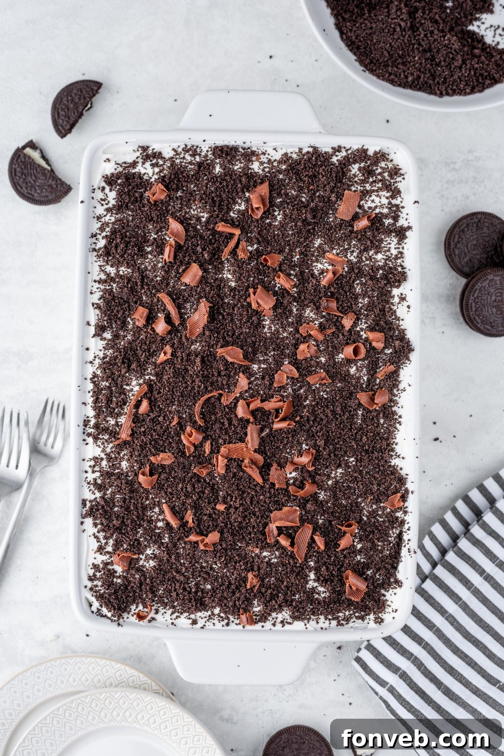 Ultimate Chocolate Oreo Delight 4 A full Chocolate Oreo Lush dessert in a clear casserole dish, surrounded by whole Oreo cookies, ready to be served.