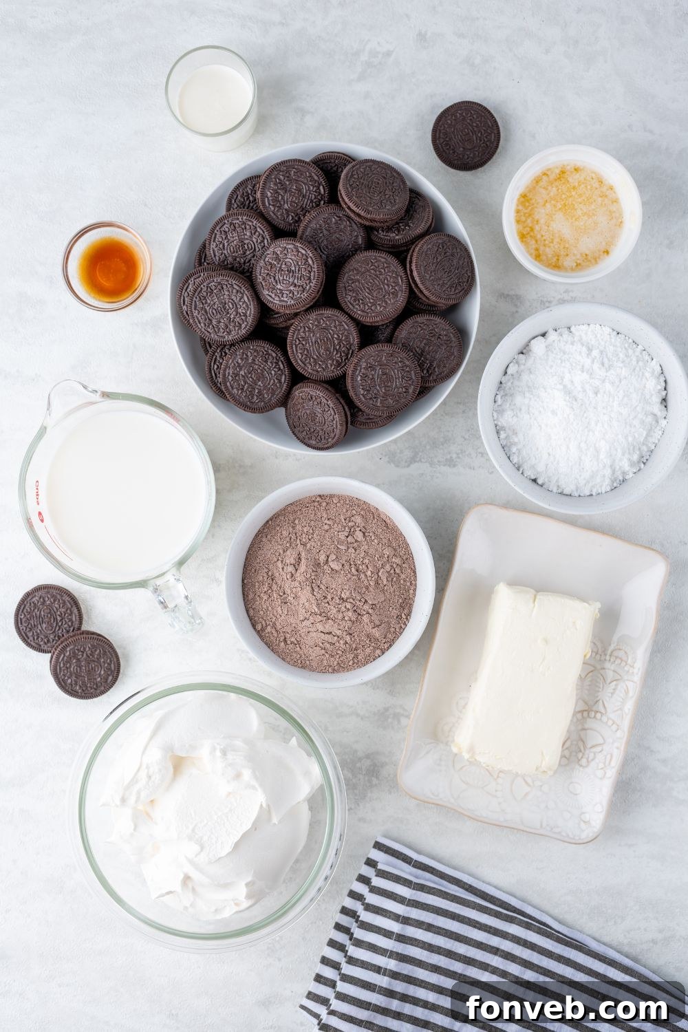 Ultimate Chocolate Oreo Delight 5 Assortment of fresh ingredients for Chocolate Oreo Lush, including Oreos, butter, cream cheese, heavy cream, powdered sugar, instant chocolate pudding mix, milk, and Cool Whip, arranged on a marble counter.