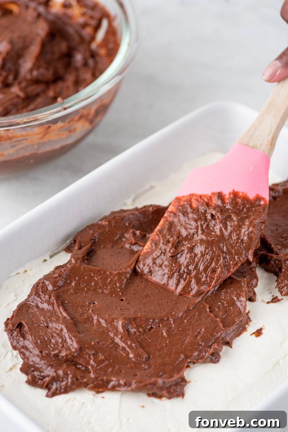 Ultimate Chocolate Oreo Delight 8 Rich chocolate pudding being spread evenly over the set cream cheese layer, creating a decadent second layer for the Chocolate Oreo Lush.