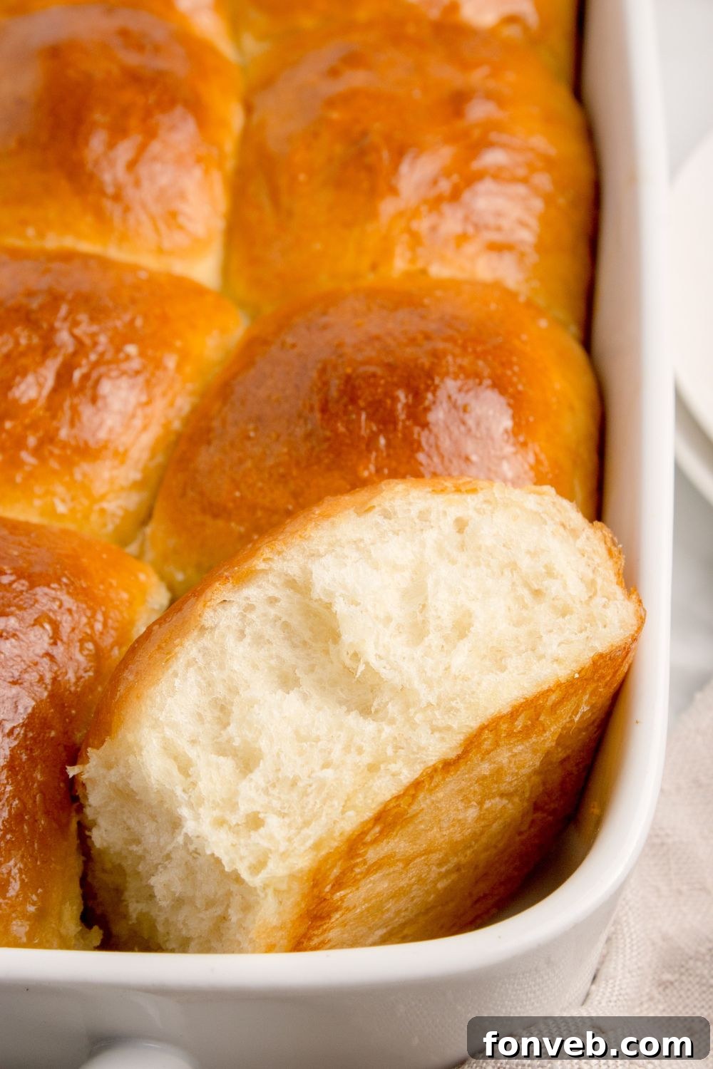 Pull Apart Rolls in a baking dish with one on the side to show the center of the dinner roll