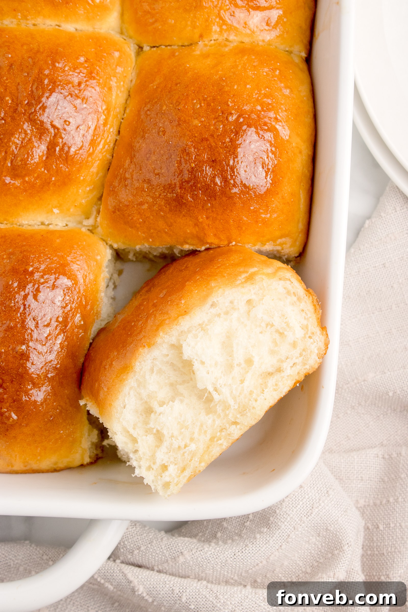 Pull Apart Dinner Rolls in a white baking dish with one cut out showing how delicious