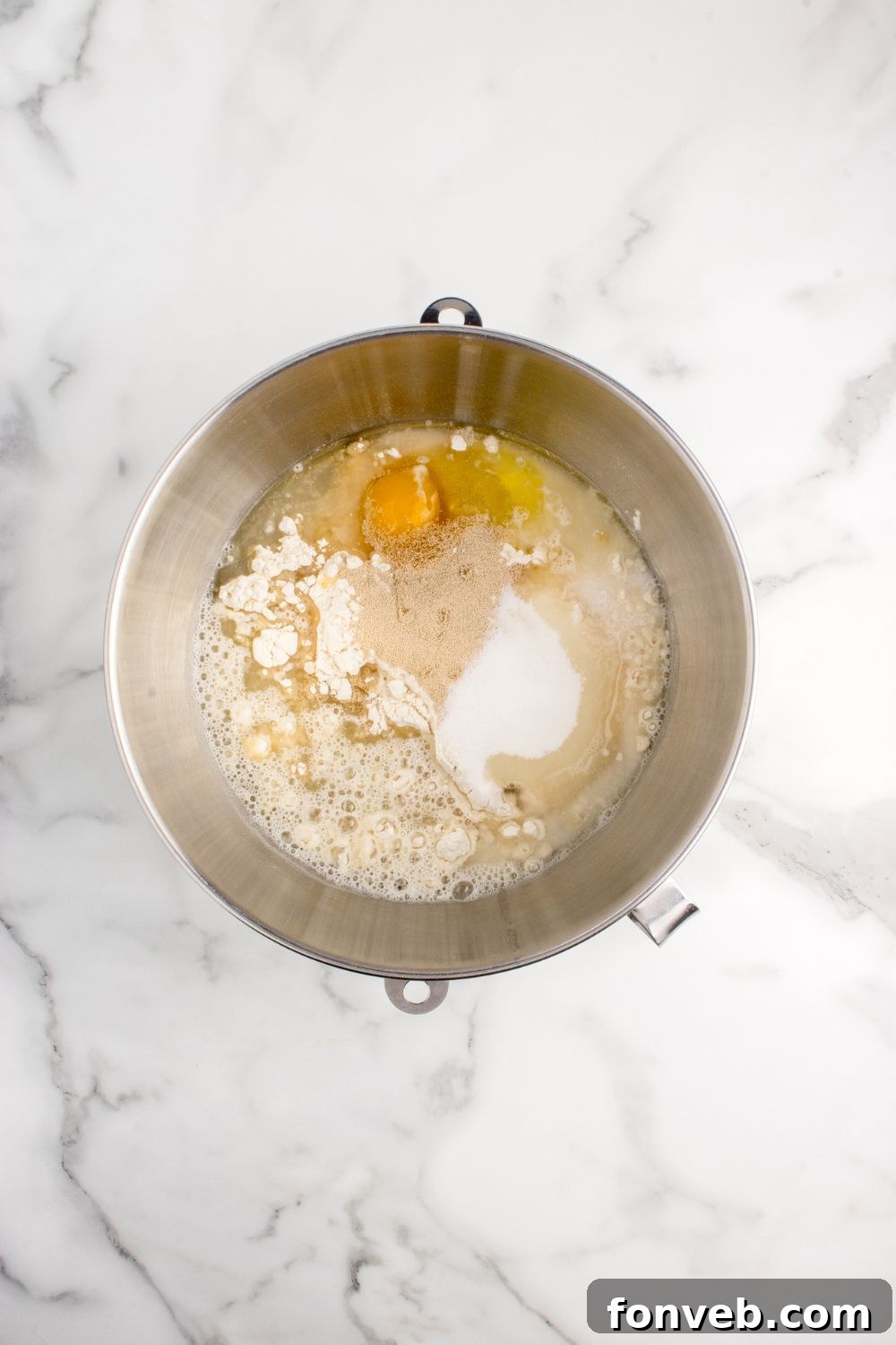 ingredients to make pull apart rolls in a mixing bowl on counter
