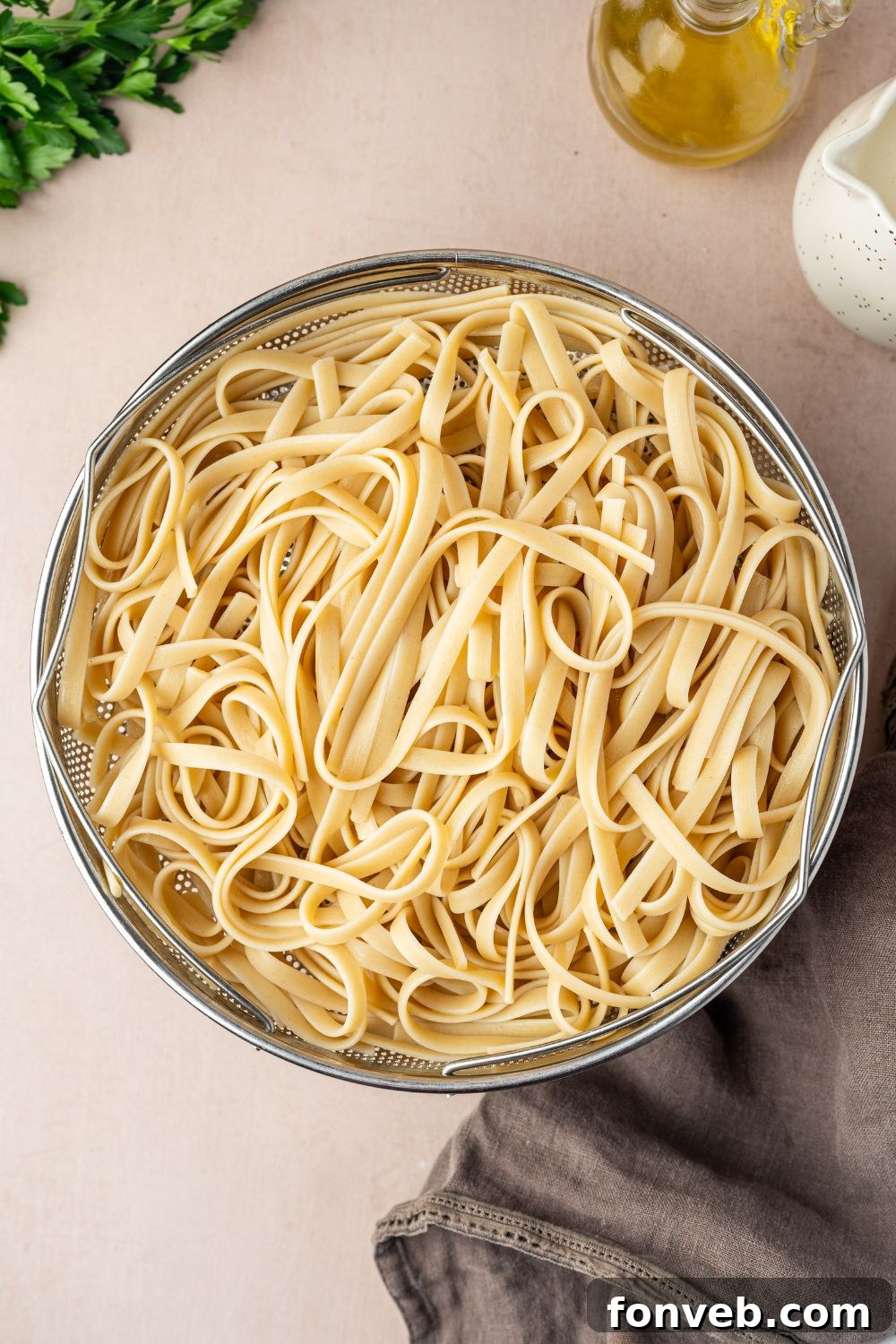 Cajun Chicken Alfredo 12 fettuccine pasta in a strainer sitting on counter