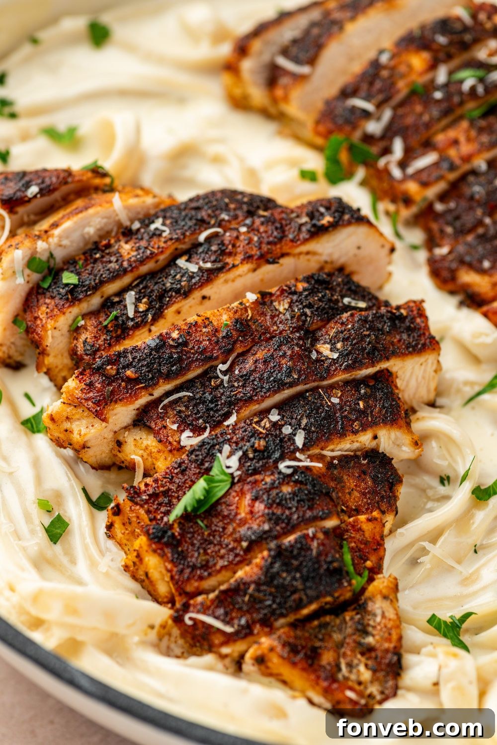 Cajun Chicken Alfredo 14 Blackened Chicken Alfredo in a bowl with a close up look of chicken on top of pasta
