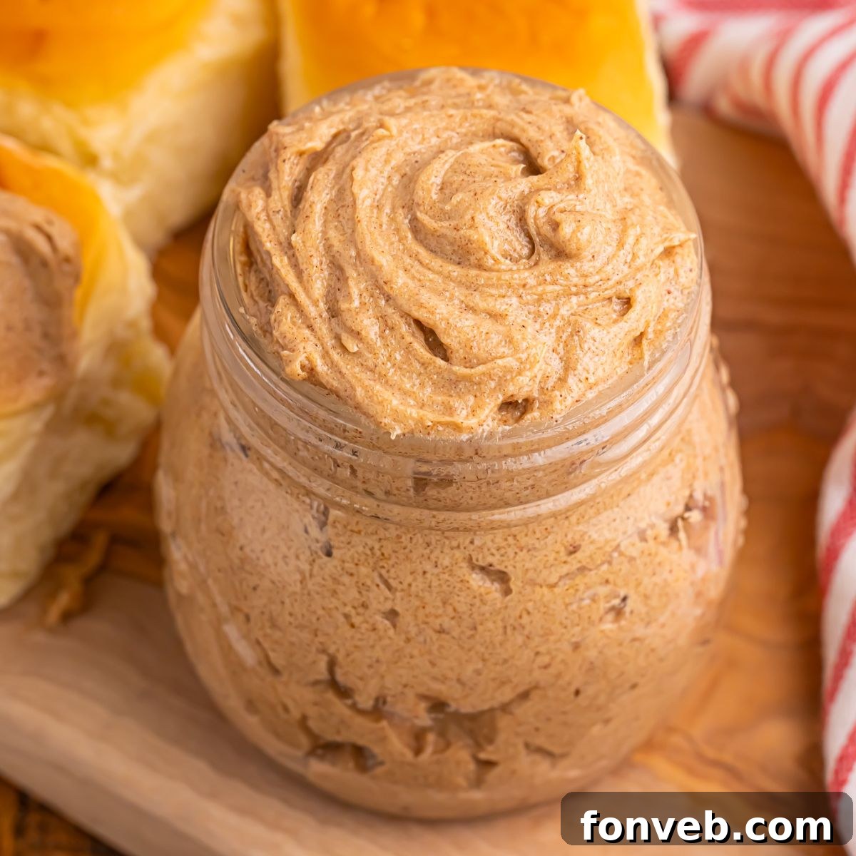 Brown Sugar Cinnamon Butter on counter in a glass jar with rolls behind it