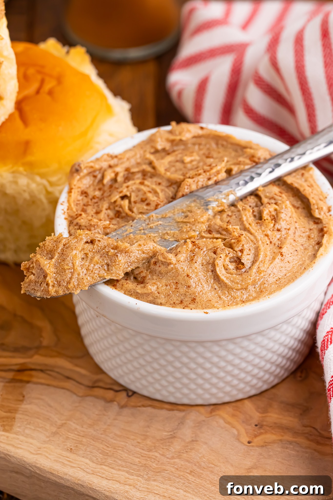 Up close shot of Brown Sugar Cinnamon Butter in a small container on table with a knife on top of bowl