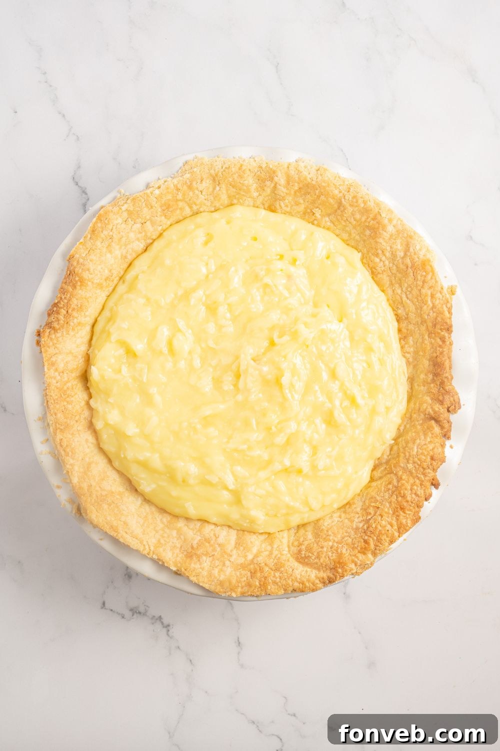 Coconut Meringue Pie filling in a pie crust on table