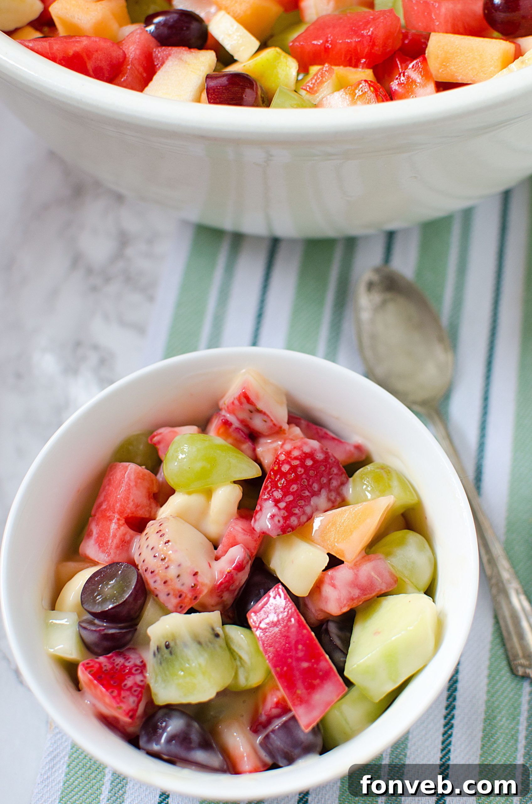 Freshly cut melon and strawberries, illustrating the preparation process for the fruit salad.