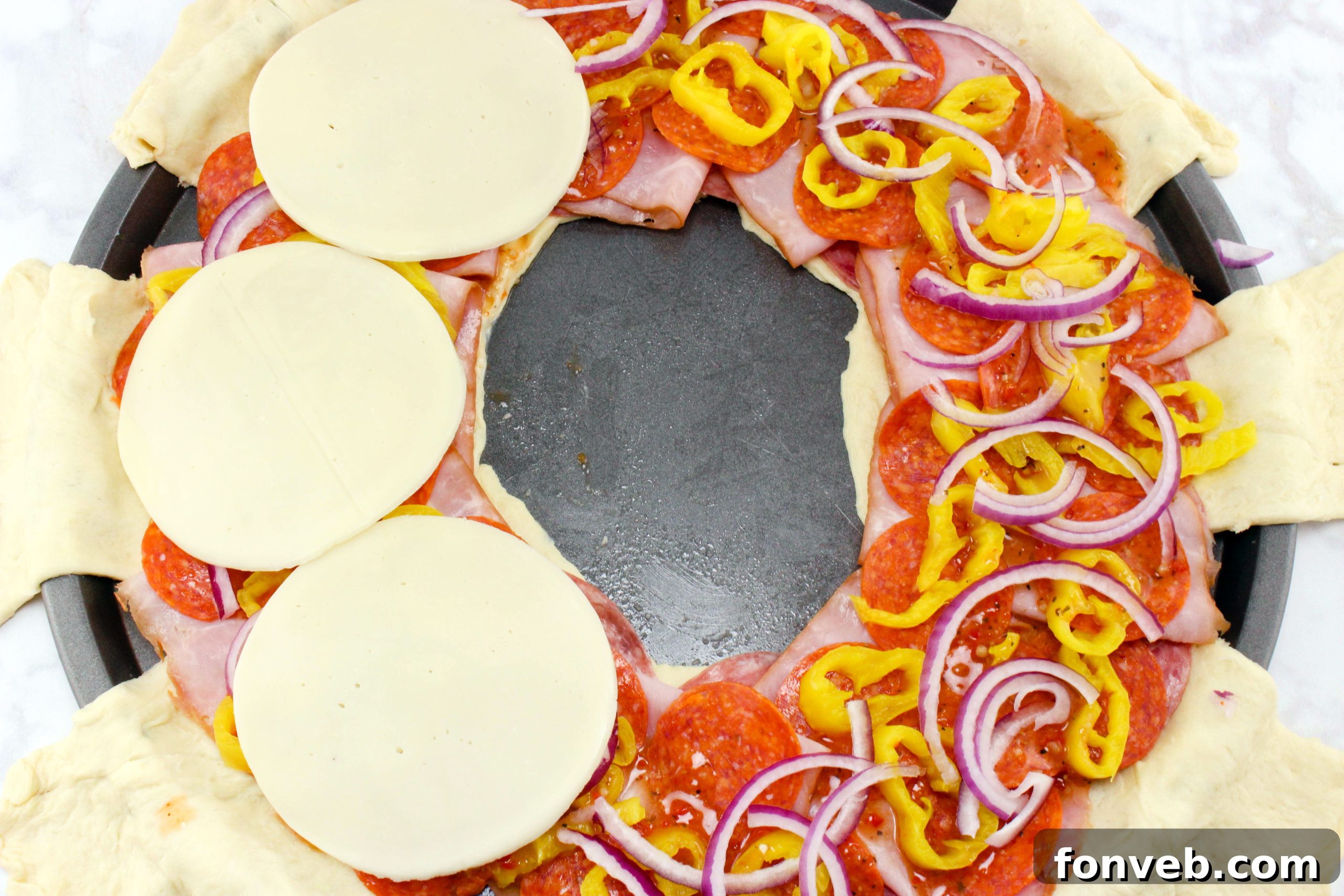 Italian Sub Crescent Bake 5 Closeup of provolone cheese slices being added to the crescent ring