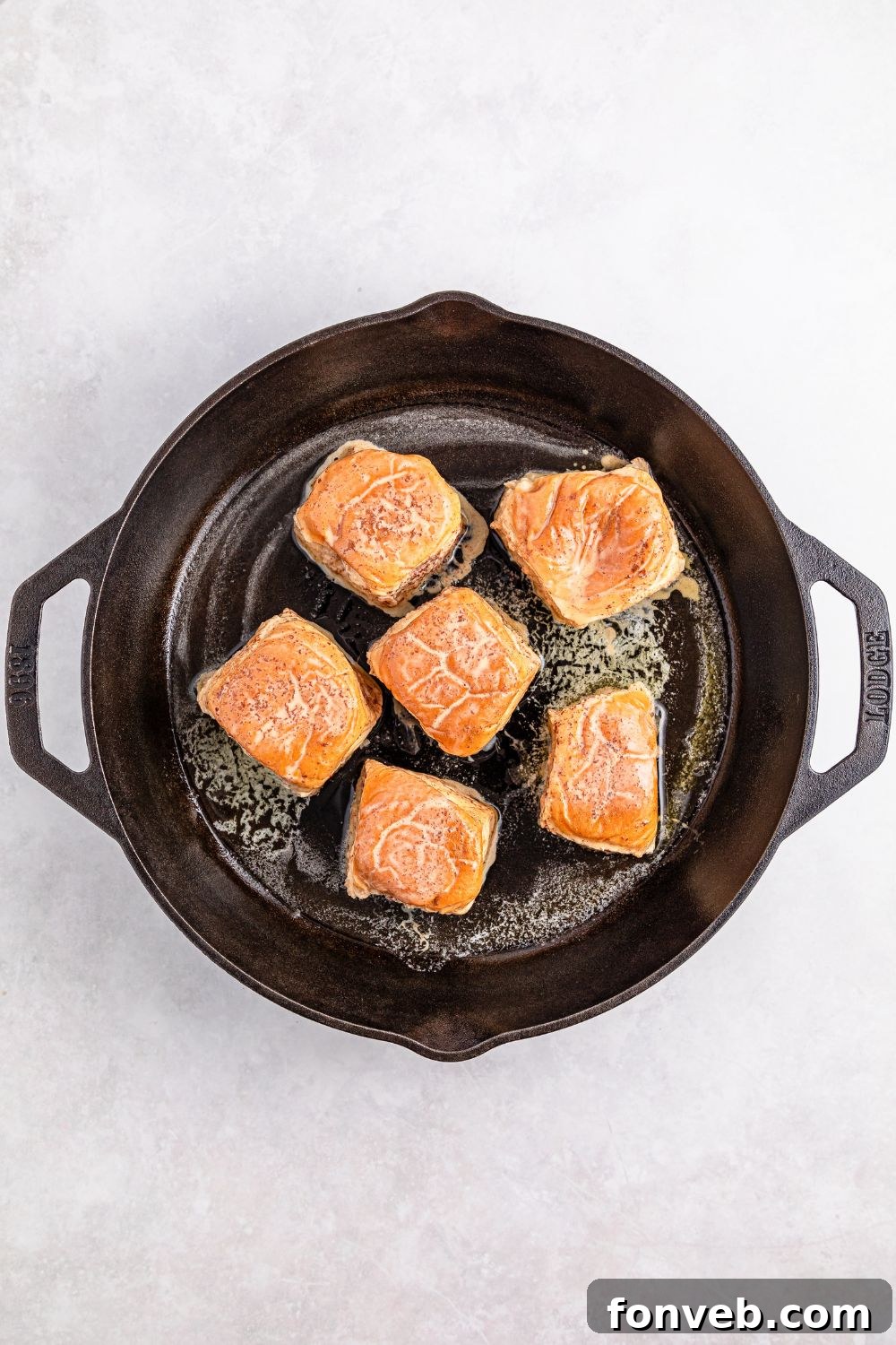 cooking up Hawaiian Roll French Toast in a cast iron skillet 