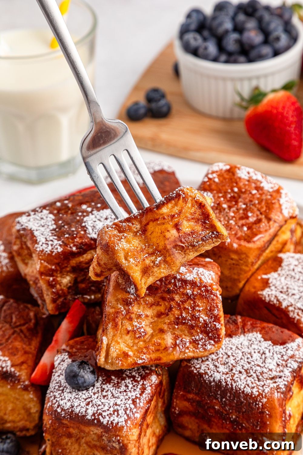 fork poking in one of the Hawaiian Roll French Toast on a plate 