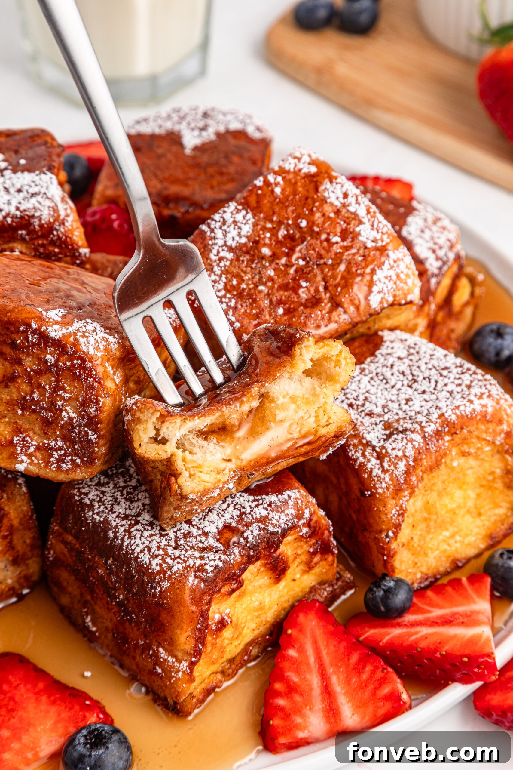 syrup on top of the Hawaiian Roll French Toast with a fork lifting up a piece